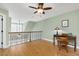Open loft area with hardwood floors, ceiling fan, and a classic desk setup at 215 Dungarven Loop, Cary, NC 27513
