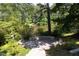 Outdoor patio area surrounded by lush greenery and a scenic lake view at 227 Shalimar Dr, Durham, NC 27713