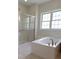 Bathroom featuring a walk-in shower with glass door, tub, and window at 227 Shalimar Dr, Durham, NC 27713