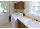 A laundry room with washer, dryer, utility sink, and cabinet storage at 227 Shalimar Dr, Durham, NC 27713
