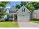 Charming two-story home featuring light-blue siding, black shutters, and an attached two-car garage at 2409 Horizon Hike Ct, Raleigh, NC 27603