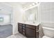 Well-lit bathroom featuring a double sink vanity with dark wood cabinets and a neutral-toned tile floor at 254 Arlie Ln, Lillington, NC 27546