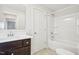 Clean bathroom with a combination tub and shower, a vanity with drawers, and a white door at 254 Arlie Ln, Lillington, NC 27546