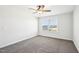 Neutral carpeted bedroom with a ceiling fan and a large window offering natural light at 254 Arlie Ln, Lillington, NC 27546