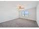 A bright bedroom with neutral walls and carpet, features a window letting in natural light and a ceiling fan at 254 Arlie Ln, Lillington, NC 27546