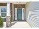Front porch with stone pillars and a teal door with windows at 254 Arlie Ln, Lillington, NC 27546