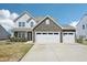 Beautiful two-story home featuring a stone facade and a three-car garage at 254 Arlie Ln, Lillington, NC 27546
