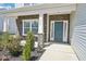 Front porch with stone pillars and an teal front door at 254 Arlie Ln, Lillington, NC 27546