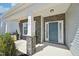 Covered front porch with stone columns and an teal door with decorative windows at 254 Arlie Ln, Lillington, NC 27546