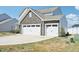 Home featuring two white garages doors accented by stone finish at 254 Arlie Ln, Lillington, NC 27546