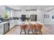Modern kitchen features white cabinets, stainless steel appliances, black backsplash, and island with barstool seating at 2724 Sammish Way, Raleigh, NC 27616