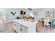 Modern kitchen with white cabinets and an island adjoins a living room and dining area in a bright, open layout at 2724 Sammish Way, Raleigh, NC 27616