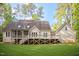 Rear view of the home featuring a spacious deck, screened porch, and large backyard at 286 Harrison Pond Dr, Pittsboro, NC 27312