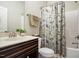 Well-lit bathroom with a floral curtain design and a dark-stained wooden cabinet at 286 Harrison Pond Dr, Pittsboro, NC 27312