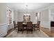 Light filled dining room boasts large windows, beautiful hardwood floors, and modern chandelier at 286 Harrison Pond Dr, Pittsboro, NC 27312