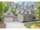 Spacious home with a three-car garage, featuring stone accents and a long driveway at 286 Harrison Pond Dr, Pittsboro, NC 27312