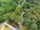 Aerial view of a home nestled among lush trees with long driveway and wooded surroundings at 2968 Tram Rd, Fuquay Varina, NC 27526