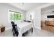 Dining room with a window, dining table with six chairs, herringbone tile floor, and view into kitchen at 2968 Tram Rd, Fuquay Varina, NC 27526