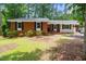 Charming brick home featuring a well-manicured lawn and mature trees at 2968 Tram Rd, Fuquay Varina, NC 27526