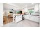 Modern kitchen features white cabinets, stainless steel appliances, concrete countertops, and tiled floors at 2968 Tram Rd, Fuquay Varina, NC 27526