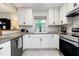 Stylish kitchen features white cabinets, subway tile backsplash, and stainless steel appliances for a modern design at 2968 Tram Rd, Fuquay Varina, NC 27526