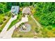 Aerial view of a yellow cottage-style home, landscaping, and driveway nestled among lush greenery at 2975 Carolyn Dr, Durham, NC 27703