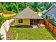 Aerial view of a well-maintained backyard with a yellow house, green grass and a screened-in porch at 2975 Carolyn Dr, Durham, NC 27703
