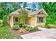 Inviting yellow cottage-style home with manicured lawn, walkway, and charming architectural details at 2975 Carolyn Dr, Durham, NC 27703