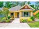 Charming yellow cottage-style home boasts a walkway and front porch framed by manicured landscaping at 2975 Carolyn Dr, Durham, NC 27703