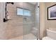 Modern shower featuring glass door, light gray tiling, window, and a built in shower seat at 2975 Carolyn Dr, Durham, NC 27703