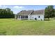 Expansive backyard featuring a lush lawn and view of the house's screened porch and back entry at 3705 Highland Creek Dr, Apex, NC 27539