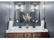 Stylish bathroom with double sink vanity, oval mirrors, modern lighting and blue-grey walls at 3705 Highland Creek Dr, Apex, NC 27539