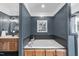 Modern bathroom featuring a luxurious soaking tub with blue-grey accent wall and wood-look vanity at 3705 Highland Creek Dr, Apex, NC 27539