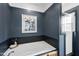 Modern bathroom featuring a luxurious soaking tub with blue-grey accent wall and wood-look vanity at 3705 Highland Creek Dr, Apex, NC 27539