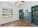Sunlit home office with hardwood floors, two windows and stylish bookcases with emerald green wall accents at 3705 Highland Creek Dr, Apex, NC 27539