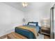 Comfortable bedroom with bed, side table and white paneled walls and hardwood floors at 3705 Highland Creek Dr, Apex, NC 27539
