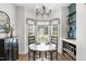 Bright breakfast nook with bay window, chandelier, built in shelving and a modern table at 3705 Highland Creek Dr, Apex, NC 27539