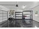 Finished garage with epoxy floors, storage shelves, a garage door and an exterior door to the yard at 3705 Highland Creek Dr, Apex, NC 27539