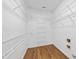 Spacious walk-in closet featuring custom shelves and laminate floors at 3705 Highland Creek Dr, Apex, NC 27539