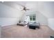 Spacious attic area with neutral carpet, dormer windows, and comfortable furnishings at 386 Monteith Dr, Chapel Hill, NC 27516