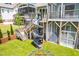 Home's backyard shows the deck leading to a spiral slide and dome climber surrounded by green lawn at 386 Monteith Dr, Chapel Hill, NC 27516
