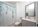 Well-lit bathroom featuring a vanity with a framed mirror, a toilet, and a shower with a floral curtain at 386 Monteith Dr, Chapel Hill, NC 27516