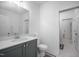 Well-lit bathroom featuring a gray vanity, toilet, and a doorway leading to another room at 386 Monteith Dr, Chapel Hill, NC 27516