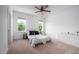 Bright bedroom with two windows, a ceiling fan and a modern bed with neutral decor at 386 Monteith Dr, Chapel Hill, NC 27516