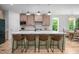 Bright kitchen features a large island with seating, pendant lights, stainless steel appliances, and wooden cabinetry at 386 Monteith Dr, Chapel Hill, NC 27516