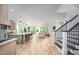 Open-concept living space with a kitchen island, hardwood floors, staircase, and an open area for relaxing at 386 Monteith Dr, Chapel Hill, NC 27516