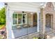 Inviting porch with cozy seating, ceiling fan and brick archway leading to the front door at 386 Monteith Dr, Chapel Hill, NC 27516