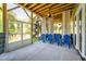 View of the screened porch with wooden beams, blue chairs, and a slide at 386 Monteith Dr, Chapel Hill, NC 27516