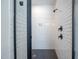 Modern shower with white subway tile, a black shower head, and hexagon tile flooring at 386 Monteith Dr, Chapel Hill, NC 27516