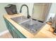 Convenient wet bar sink with built in dishwasher and stylish faucet and green cabinetry at 386 Monteith Dr, Chapel Hill, NC 27516